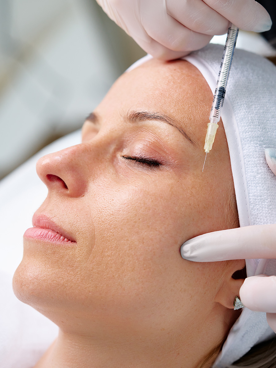 A mature woman getting an injection in her face