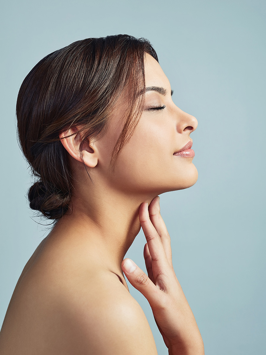 Profile of a young woman touching her neck