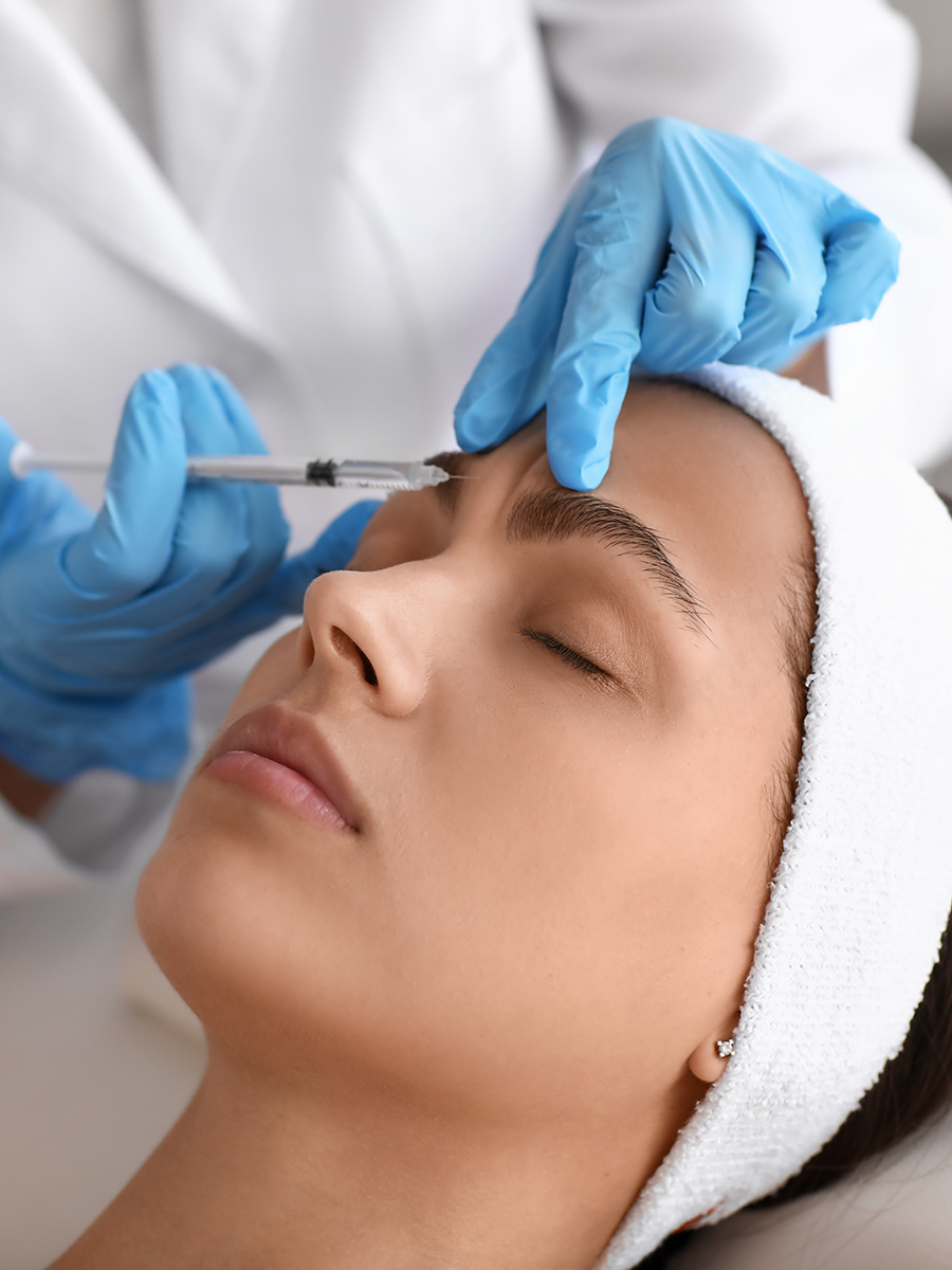 Woman getting an injection by a person in blue gloves