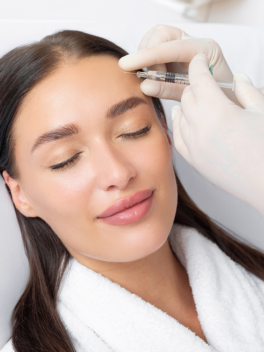 Young woman getting forehead injection
