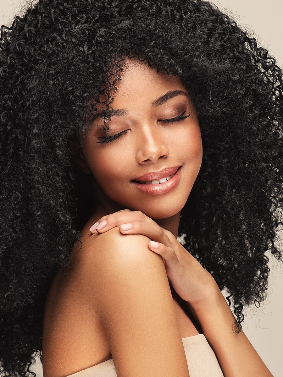 Woman with curly hair looking over her shoulder